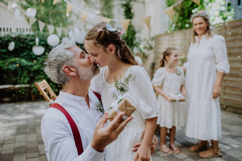 Ein reifer Vater Bräutigam erhalten Geschenk von seiner Tochter bei der Hochzeitsfeier draußen im Hinterhof. - HPIF09534