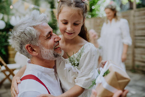 Ein reifer Vater Bräutigam erhalten Geschenk von seiner Tochter bei der Hochzeitsfeier draußen im Hinterhof. - HPIF09535