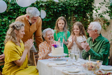 A multi-generation family on outdoor summer garden party, celebrating birthday - HPIF09575