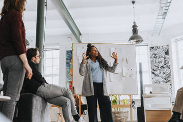 Businesswoman explaining colleagues during meeting at office - MASF36836