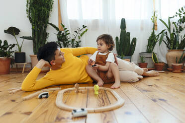 Mother lying down by son playing at home - EBSF03279