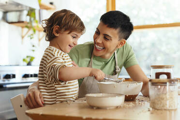 Son mixing flour by happy mother at home - EBSF03306