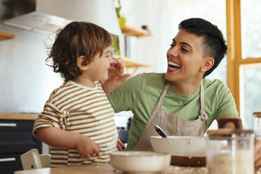 Glückliche Frau berührt die Nase ihres Sohnes in der Küche zu Hause - EBSF03307