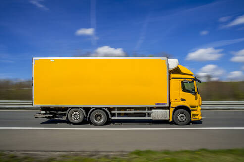 Germany, North Rhine Westphalia, Yellow truck driving along A 46 - FRF01018