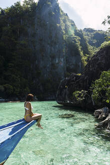 Woman looking at sea sitting on boat - PNAF05270