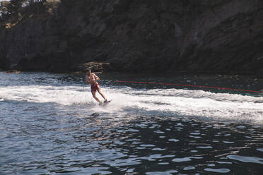 Young man doing water sports in sea at vacation - PCLF00502