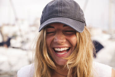 Happy young woman laughing at harbor - PCLF00514