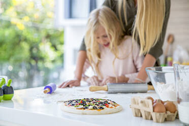 Fresh pizza with mother and daughter in kitchen at home - IKF00509