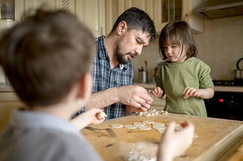 Vater bringt Kindern in der Küche bei, wie man Knödel macht - ANAF01390