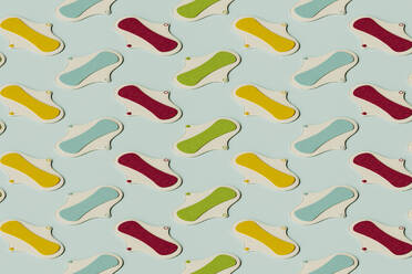 3D pattern of colorful sanitary pads flat laid against green background - GCAF00325