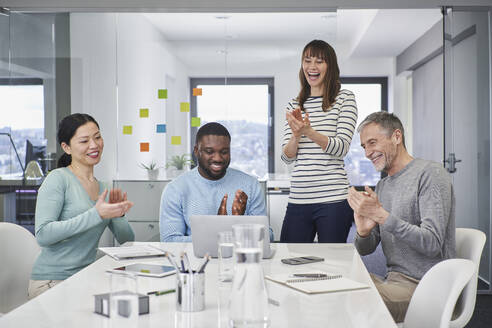 Colleagues applauding on video conference in meeting - RORF03540