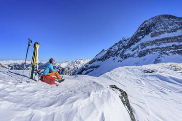 Österreich, Tirol, Skifahrerin macht Pause am Torhelm - ANSF00269