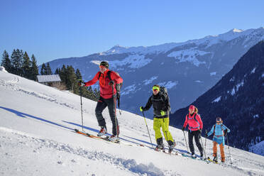 Austria, Tyrol, Group of skiers ascending snowcapped slope of Kellerjoch mountain - ANSF00270