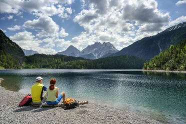 Österreich, Tirol, Wanderpaar entspannt am Ufer des Blindsees - ANSF00306