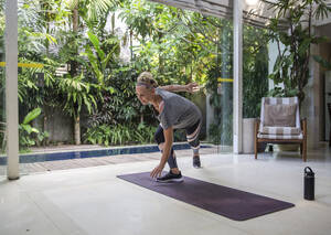 Woman exercising in living room at home - IKF00538