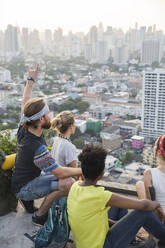 Freunde genießen den Blick auf die Stadt von der Dachterrasse aus - IKF00579