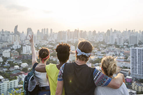 Freunde genießen die Aussicht auf die Stadt bei Sonnenuntergang - IKF00586