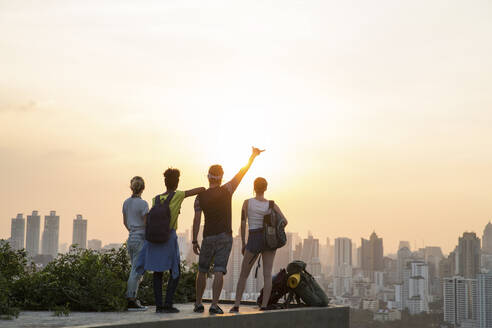 Friends enjoying sunset view from rooftop - IKF00590