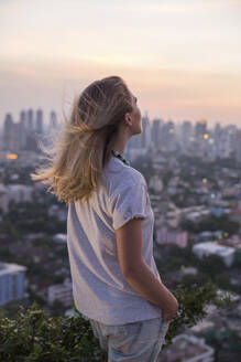 Woman with hand in pocket enjoying at rooftop - IKF00603