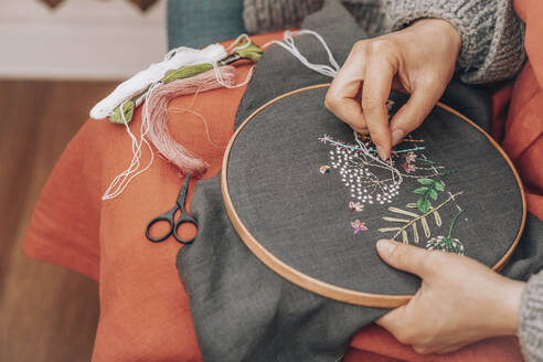 Hände einer Modedesignerin beim Sticken auf Stoff mit Faden in einem Workshop - ADF00012