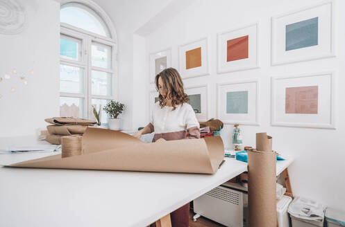 Modedesigner beim Arrangieren von Geschenkpapier im Workshop - ADF00017