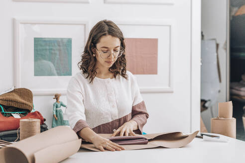 Modedesigner verpackt Kleid in Geschenkpapier bei einem Workshop - ADF00027