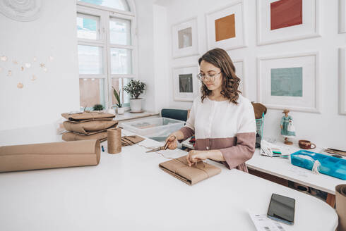 Modedesigner beim Verpacken von Aufträgen in der Werkstatt - ADF00030