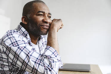 Thoughtful businessman leaning on elbow at table - EYAF02635