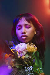 Neon lights over woman with colorful flowers - YTF00825