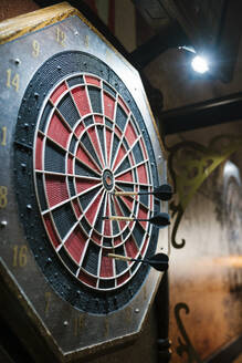 Darts hitting target on dartboard in bar - EGAF02597