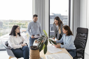 Business people working together on an architectural project in office - KMKF01958