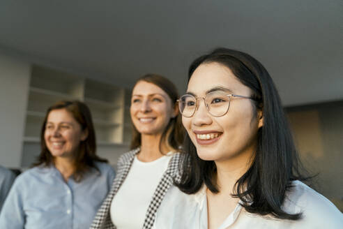 Three smiling businesswomen in office - KMKF02006