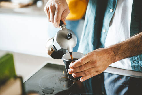 Hands of man pouring coffee from coffee maker in cup - JOSEF19032