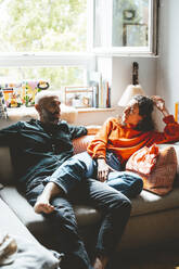 Mann und Frau entspannen sich auf dem Sofa zu Hause - JOSEF19099