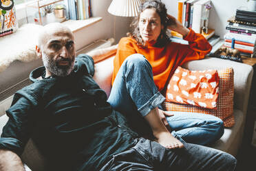 Multiracial couple sitting on sofa at home - JOSEF19100