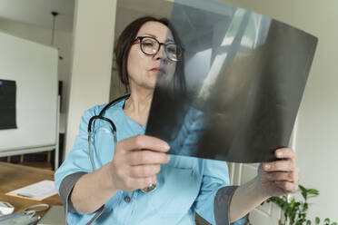 Konzentrierter Arzt bei der Untersuchung von Röntgenbildern in einer Arztpraxis - OSF01559