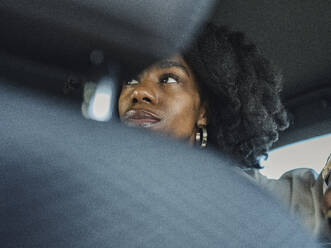 Nachdenkliche Frau mit lockigem Haar im Auto - MFF09316