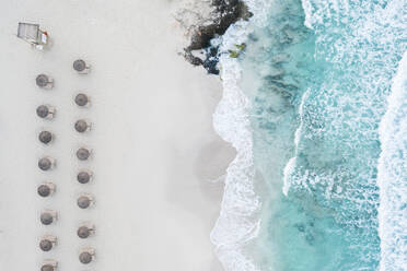 Spanien, Balearische Inseln, Formentera, Drohnenaufnahme von Reihen von Sonnenschirmen am leeren Strand - MMAF01459