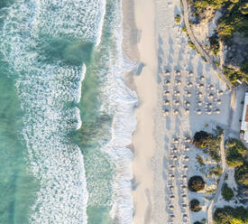 Spanien, Balearische Inseln, Formentera, Drohnenaufnahme von Reihen von Sonnenschirmen am leeren Strand - MMAF01468