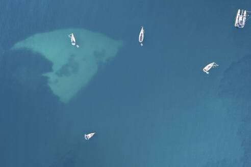 Spain, Balearic Islands, Formentera, Drone view of boats floating on blue surface of Mediterranean Sea - MMAF01477