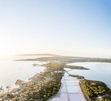 Spain, Balearic Islands, Formentera, Drone view of setting sun illuminating salt flats in Ses Salines Natural Park - MMAF01482