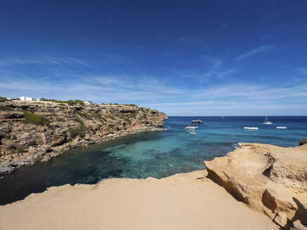 Spain, Balearic Islands, Formentera, Beach with cliffs and boats in background - MMAF01487