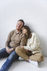 Mann und Frau sitzen zusammen auf dem Boden - EYAF02667