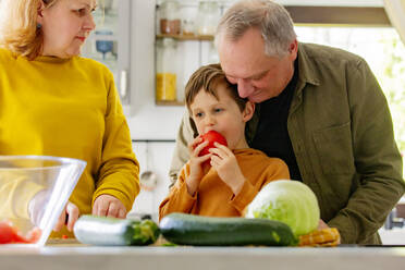 Großeltern machen Salat mit Enkel in der Küche zu Hause - VSNF00844