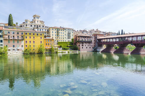 Italien, Venetien, Bassano del Grappa, Fluss Brenta mit Gebäuden und Ponte Vecchio im Hintergrund - FLMF00947