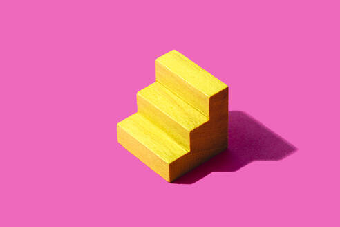 3D render of wooden steps block against pink background - FLMF00954