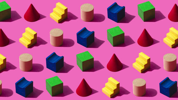 3D pattern of colorful toy blocks flat laid against pink background - FLMF00958