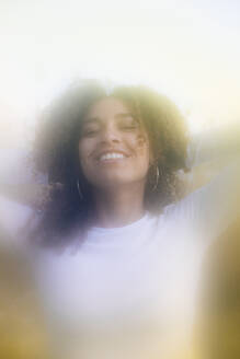 Happy young woman with curly hair - MRAF00940