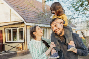 Happy family spending leisure time in front yard - ANAF01433