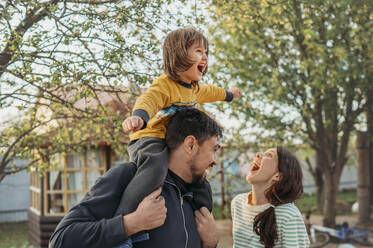 Happy family enjoying in front yard - ANAF01434